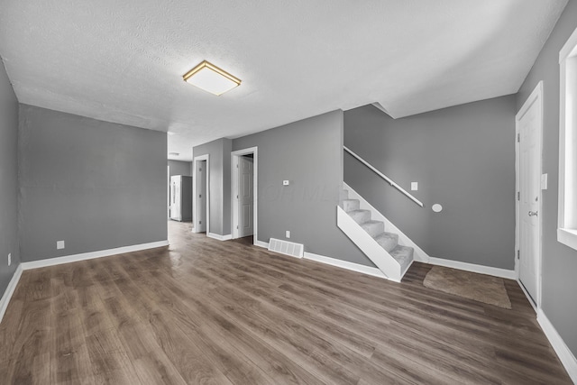 3654 Arnelle Rd, Columbus, OH 43228 - unfurnished living room featuring stairs, wood finished floors, and a textured ceiling