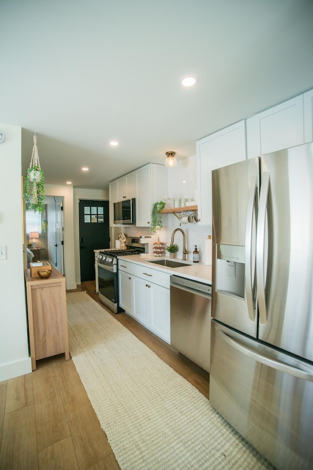 853 Thurman Ave, Columbus, OH 43206 - kitchen featuring stainless steel appliances, light wood finished floors, white cabinetry, and recessed lighting