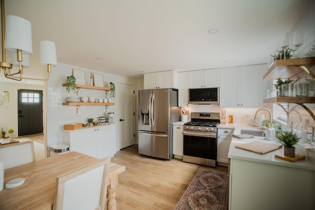 853 Thurman Ave, Columbus, OH 43206 - kitchen with open shelves, appliances with stainless steel finishes, light countertops, and white cabinets