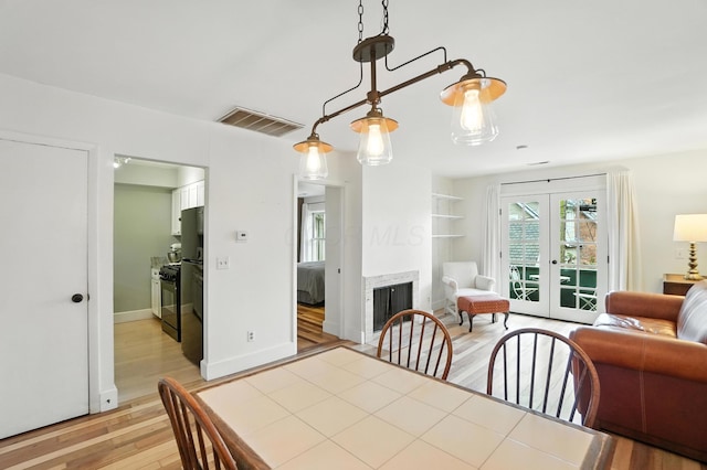 253 Kossuth St Unit H, Columbus, OH 43223 - dining area featuring light wood finished floors, french doors, and a fireplace
