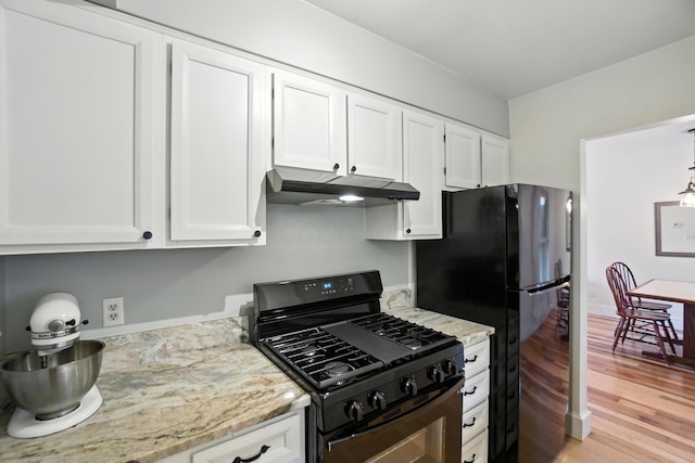 253 Kossuth St Unit H, Columbus, OH 43223 - kitchen featuring black appliances, under cabinet range hood, white cabinetry, light wood finished floors, and light stone counters