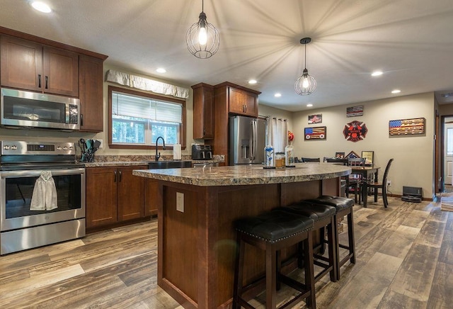 19366 Laurel Run Rd, Nelsonville, OH 45764 - kitchen with stainless steel appliances, dark wood-style flooring, a center island, a kitchen breakfast bar, and dark countertops