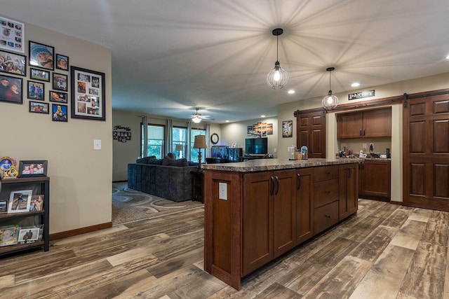 19366 Laurel Run Rd, Nelsonville, OH 45764 - kitchen featuring a barn door, dark wood-type flooring, a kitchen island, hanging light fixtures, and recessed lighting