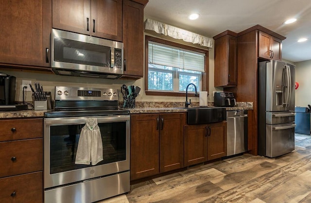 19366 Laurel Run Rd, Nelsonville, OH 45764 - kitchen featuring appliances with stainless steel finishes, light wood finished floors, dark stone countertops, and recessed lighting