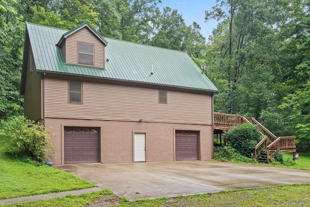 3857 US Highway 23, Chillicothe, OH 45601 - view of home's exterior with an attached garage, a metal roof, driveway, stucco siding, and a deck