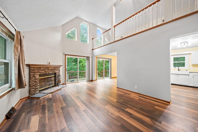 3857 US Highway 23, Chillicothe, OH 45601 - unfurnished living room featuring a stone fireplace, hardwood / wood-style floors, healthy amount of natural light, and high vaulted ceiling