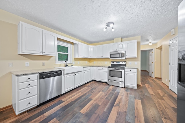 3857 US Highway 23, Chillicothe, OH 45601 - kitchen featuring stainless steel appliances, white cabinets, dark wood-type flooring, a textured ceiling, and light stone counters