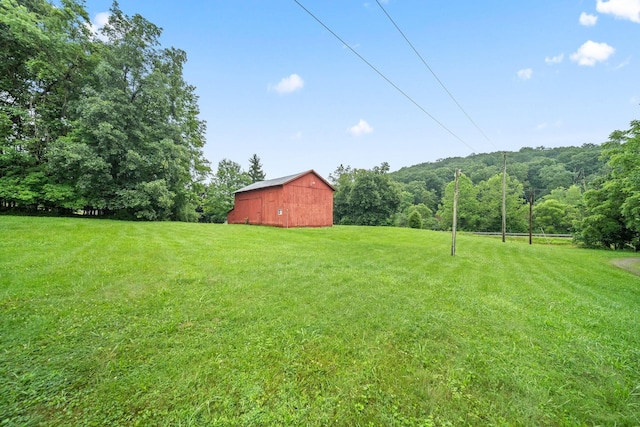 3857 US Highway 23, Chillicothe, OH 45601 - view of grassy yard featuring a barn, an outdoor structure, and a wooded view