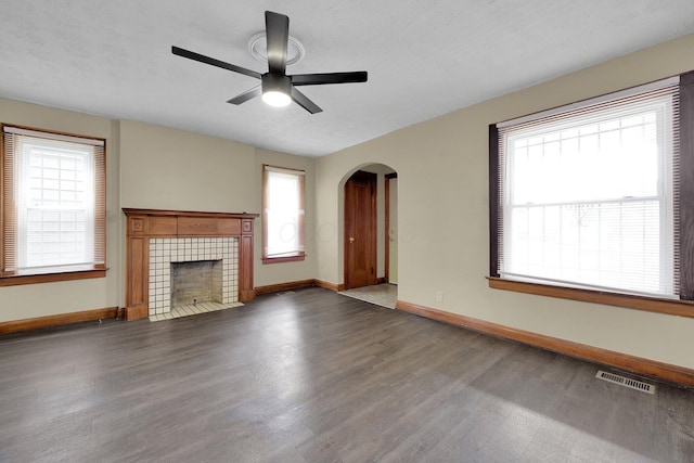 898-900 Berkeley Rd, Columbus, OH 43206 - unfurnished living room with wood finished floors, arched walkways, a ceiling fan, and a tile fireplace