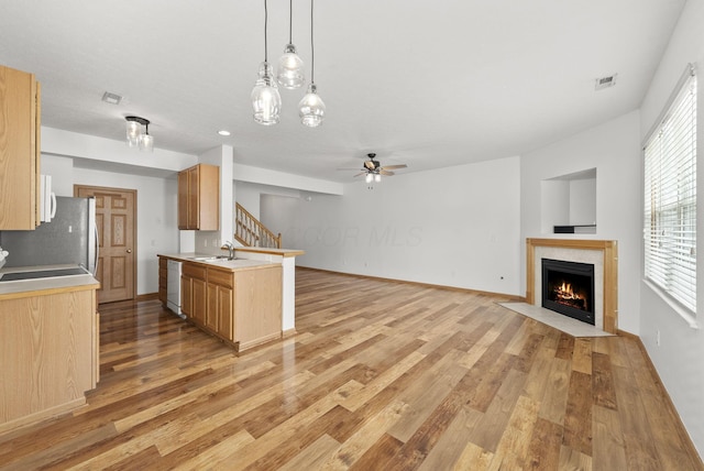 3734 Gibbstone Dr, Columbus, OH 43204 - kitchen featuring open floor plan, a fireplace with flush hearth, light wood finished floors, freestanding refrigerator, and light countertops