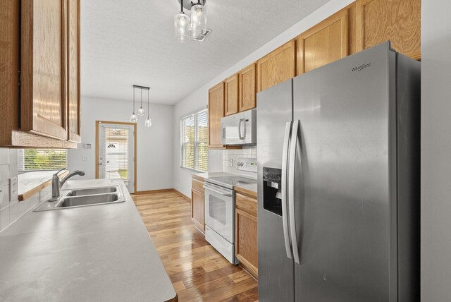 3734 Gibbstone Dr, Columbus, OH 43204 - kitchen featuring white appliances, backsplash, light wood-style flooring, and light countertops