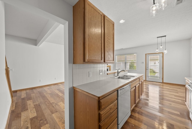 3734 Gibbstone Dr, Columbus, OH 43204 - kitchen featuring dishwasher, brown cabinets, light wood-style floors, decorative backsplash, and recessed lighting