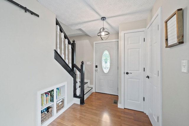 2387 Sutter Pkwy, Dublin, OH 43016 - entryway with stairway, wood finished floors, and a textured ceiling