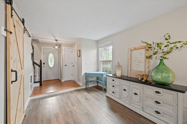 2387 Sutter Pkwy, Dublin, OH 43016 - entryway with a barn door, wood finished floors, and a textured ceiling