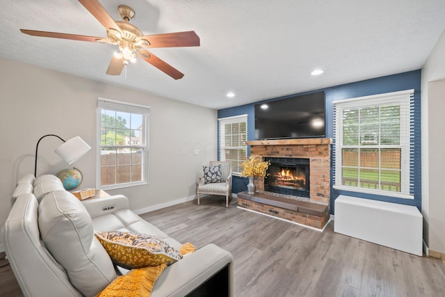 2387 Sutter Pkwy, Dublin, OH 43016 - living area with wood finished floors, a fireplace, a ceiling fan, recessed lighting, and a textured ceiling