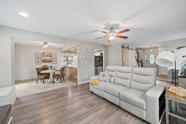 2387 Sutter Pkwy, Dublin, OH 43016 - living room with a barn door, wood finished floors, a ceiling fan, and recessed lighting
