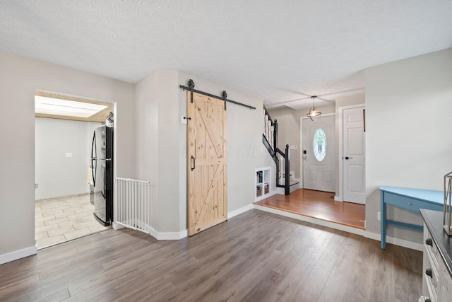 2387 Sutter Pkwy, Dublin, OH 43016 - entryway with a barn door, wood finished floors, and a textured ceiling
