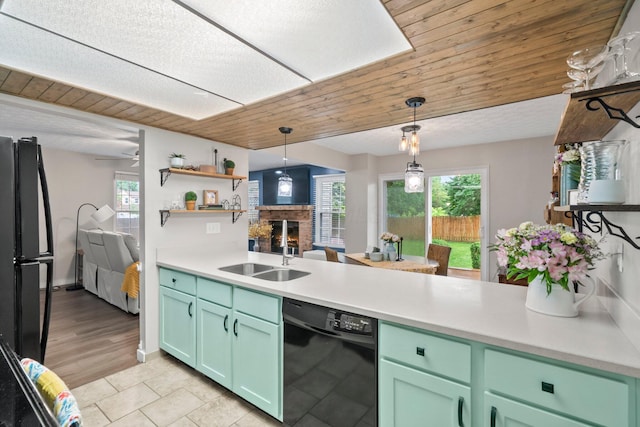 2387 Sutter Pkwy, Dublin, OH 43016 - kitchen with black appliances, a fireplace, a peninsula, and pendant lighting