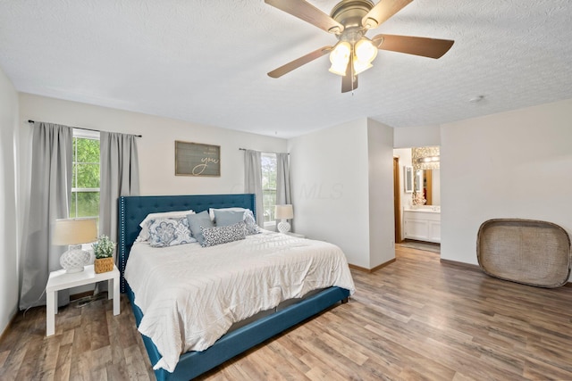 2387 Sutter Pkwy, Dublin, OH 43016 - bedroom with multiple windows, wood finished floors, a textured ceiling, a ceiling fan, and ensuite bathroom