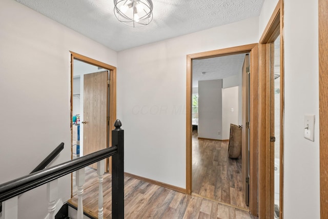 2387 Sutter Pkwy, Dublin, OH 43016 - hall with an upstairs landing, light wood-style floors, and a textured ceiling