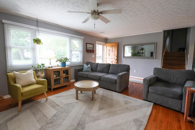 5081 Mengel Ln, Hilliard, OH 43026 - living room featuring wood finished floors, ceiling fan, stairway, crown molding, and a textured ceiling