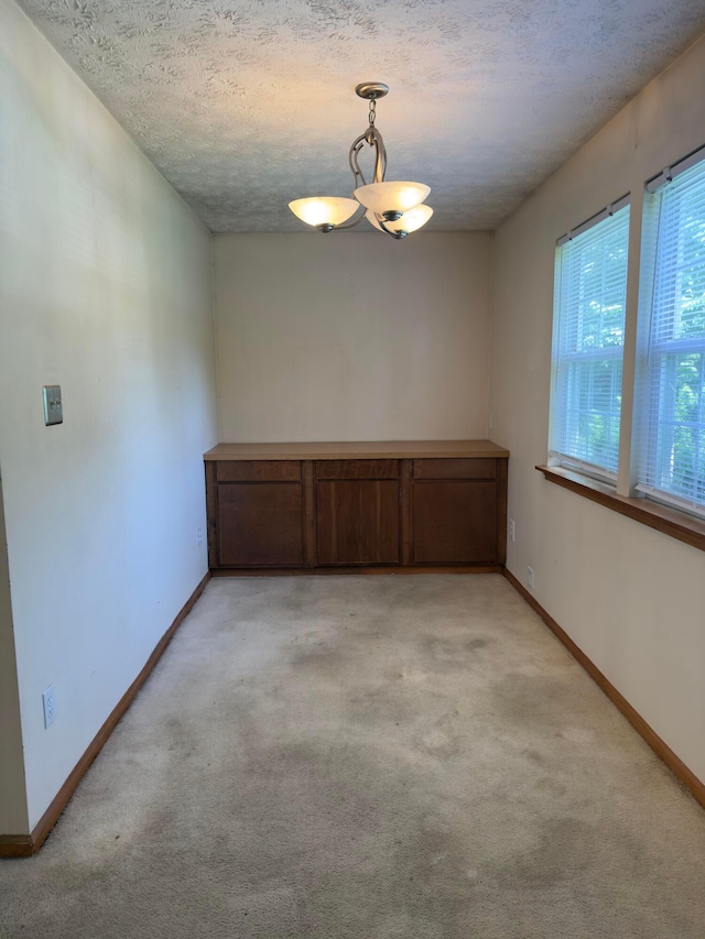 3660 Watt Rd, Columbus, OH 43230 - unfurnished room featuring light carpet, a chandelier, and a textured ceiling