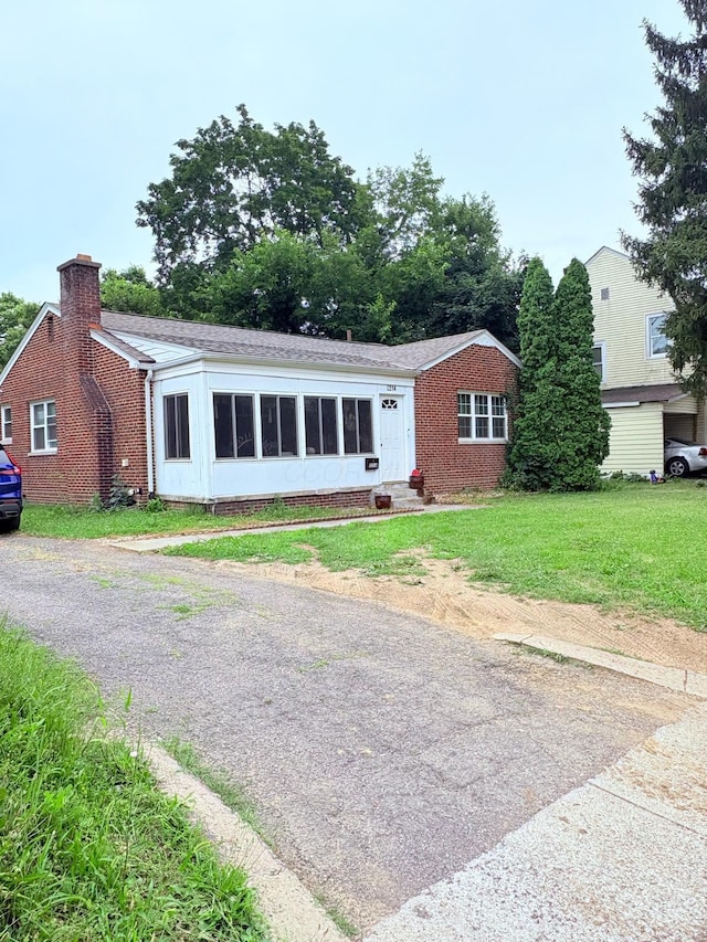 2214 Medina Ave, Columbus, OH 43211 - ranch-style house with a chimney, brick siding, a front yard, and roof with shingles