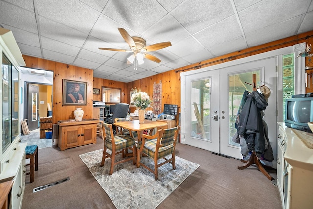 3750 Dresden St, Columbus, OH 43224 - dining space with light carpet, french doors, a drop ceiling, ceiling fan, and wood walls