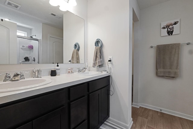 322 Honeysuckle St, South Bloomfield, OH 43103 - full bathroom with wood finished floors, double vanity, and a shower stall