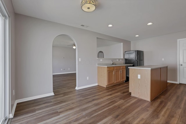 5512 Old Coble St, Canal Winchester, OH 43110 - kitchen with freestanding refrigerator, a ceiling fan, light countertops, arched walkways, and dark wood-style floors