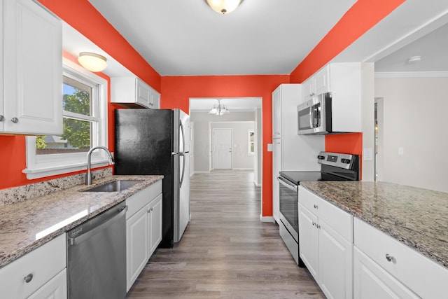 3851 Security Dr, Grove City, OH 43123 - kitchen with stainless steel appliances, white cabinets, light wood-style flooring, light stone counters, and crown molding
