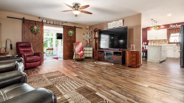 405 Meadowland Dr, Newark, OH 43055 - living room featuring light wood-style floors, plenty of natural light, a ceiling fan, and a barn door
