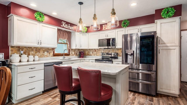405 Meadowland Dr, Newark, OH 43055 - kitchen featuring stainless steel appliances, wood finished floors, a kitchen island, backsplash, and recessed lighting