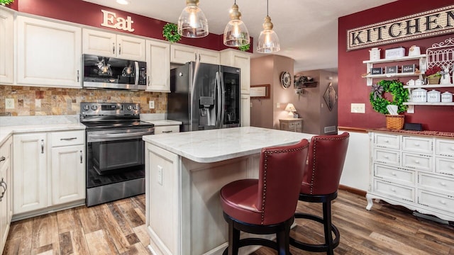 405 Meadowland Dr, Newark, OH 43055 - kitchen with stainless steel appliances, light wood-type flooring, a kitchen island, backsplash, and light stone counters