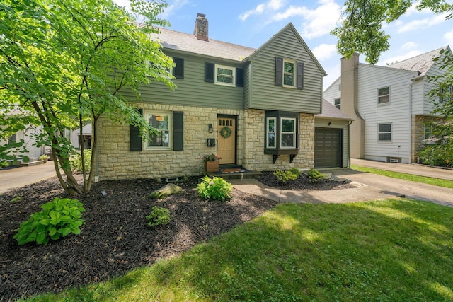 67 Aldrich Rd, Columbus, OH 43214 - view of front of home with stone siding, a garage, a front yard, driveway, and a chimney