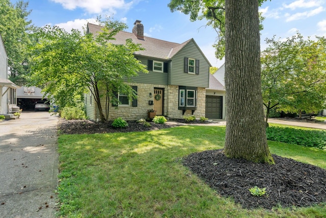 67 Aldrich Rd, Columbus, OH 43214 - colonial home featuring stone siding, a chimney, a front lawn, and driveway
