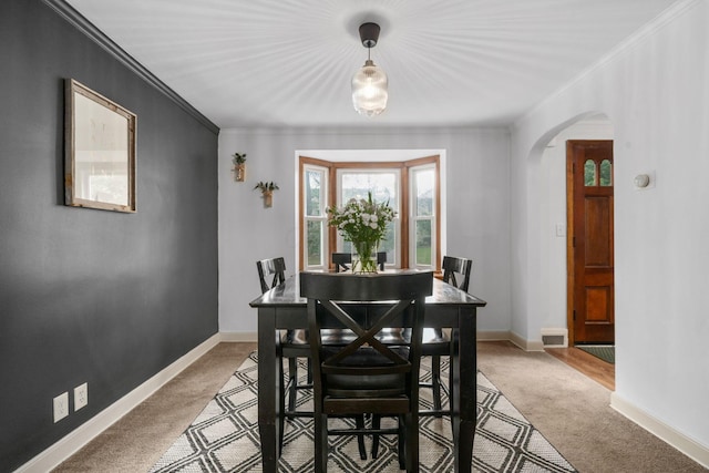 67 Aldrich Rd, Columbus, OH 43214 - dining area featuring arched walkways, light colored carpet, and ornamental molding
