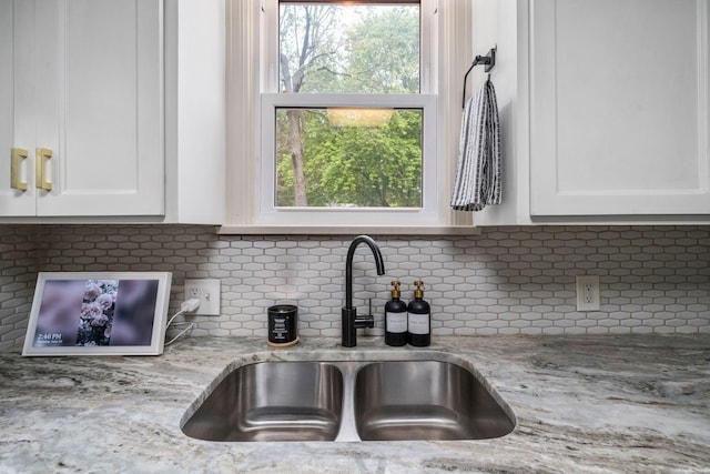 67 Aldrich Rd, Columbus, OH 43214 - kitchen with white cabinetry, light stone counters, and decorative backsplash