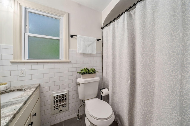 67 Aldrich Rd, Columbus, OH 43214 - bathroom featuring heating unit, tile walls, vanity, tile patterned floors, and wainscoting