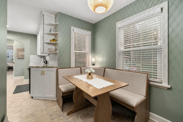 67 Aldrich Rd, Columbus, OH 43214 - dining room featuring wallpapered walls, arched walkways, and light tile patterned flooring