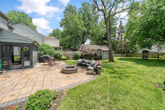 67 Aldrich Rd, Columbus, OH 43214 - fenced backyard with an outdoor fire pit, a patio, a storage shed, and a playground