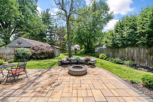 67 Aldrich Rd, Columbus, OH 43214 - fenced backyard with a patio area, a fire pit, and an outdoor structure