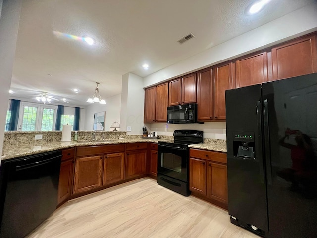 6090 Sowerby Ln, Westerville, OH 43081 - kitchen featuring black appliances, light wood-style flooring, light stone counters, recessed lighting, and brown cabinets