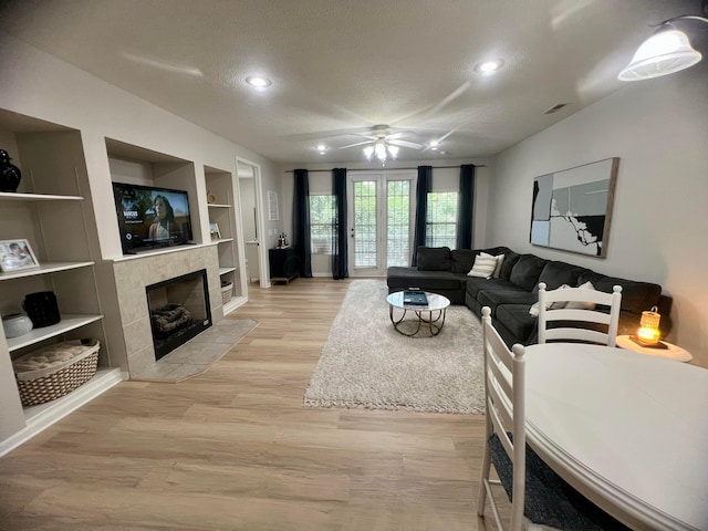 6090 Sowerby Ln, Westerville, OH 43081 - living room with a textured ceiling, a ceiling fan, recessed lighting, light wood-type flooring, and a tile fireplace