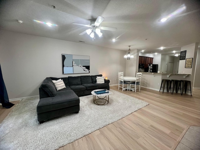 6090 Sowerby Ln, Westerville, OH 43081 - living area with light wood finished floors, ceiling fan, a textured ceiling, and a chandelier