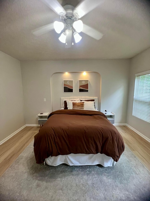 6090 Sowerby Ln, Westerville, OH 43081 - bedroom featuring light wood-type flooring, a textured ceiling, a ceiling fan, and arched walkways