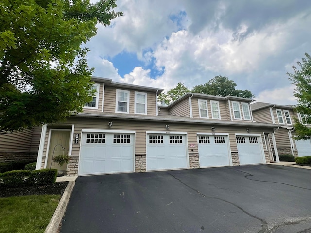 6090 Sowerby Ln, Westerville, OH 43081 - view of property with stone siding, asphalt driveway, and an attached garage