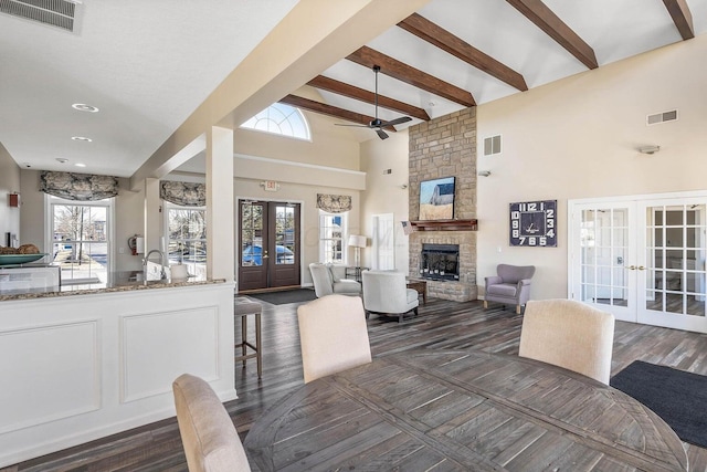 6090 Sowerby Ln, Westerville, OH 43081 - dining space with french doors, high vaulted ceiling, ceiling fan, beamed ceiling, and a stone fireplace