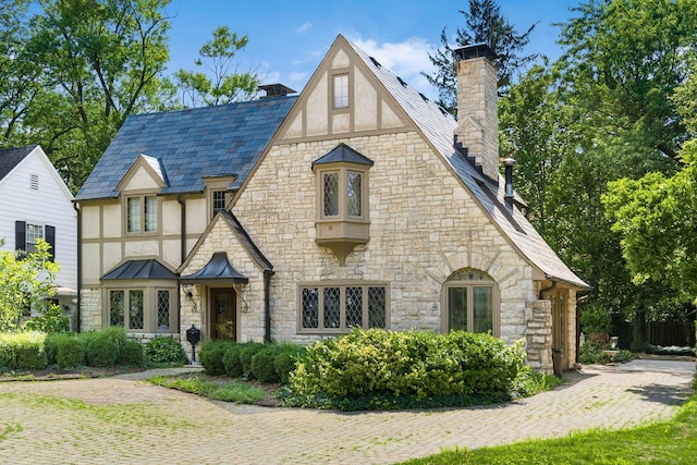 233 S Dawson Ave, Columbus, OH 43209 - tudor-style house featuring stone siding, a chimney, and stucco siding