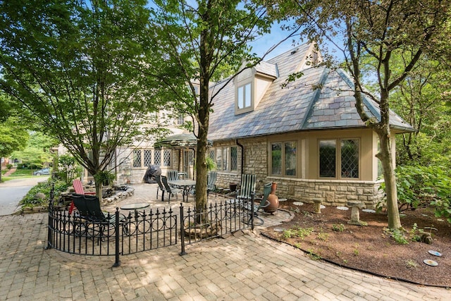 233 S Dawson Ave, Columbus, OH 43209 - view of front of home featuring stone siding, a patio, a high end roof, and stucco siding